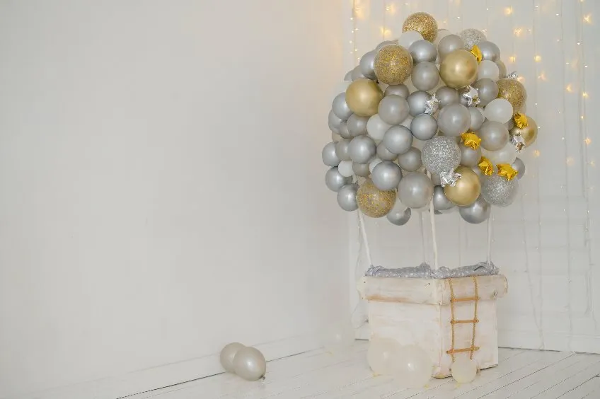 Das Bild zeigt einen Baum aus Luftballons mit sibernen und goldenem Glanz.