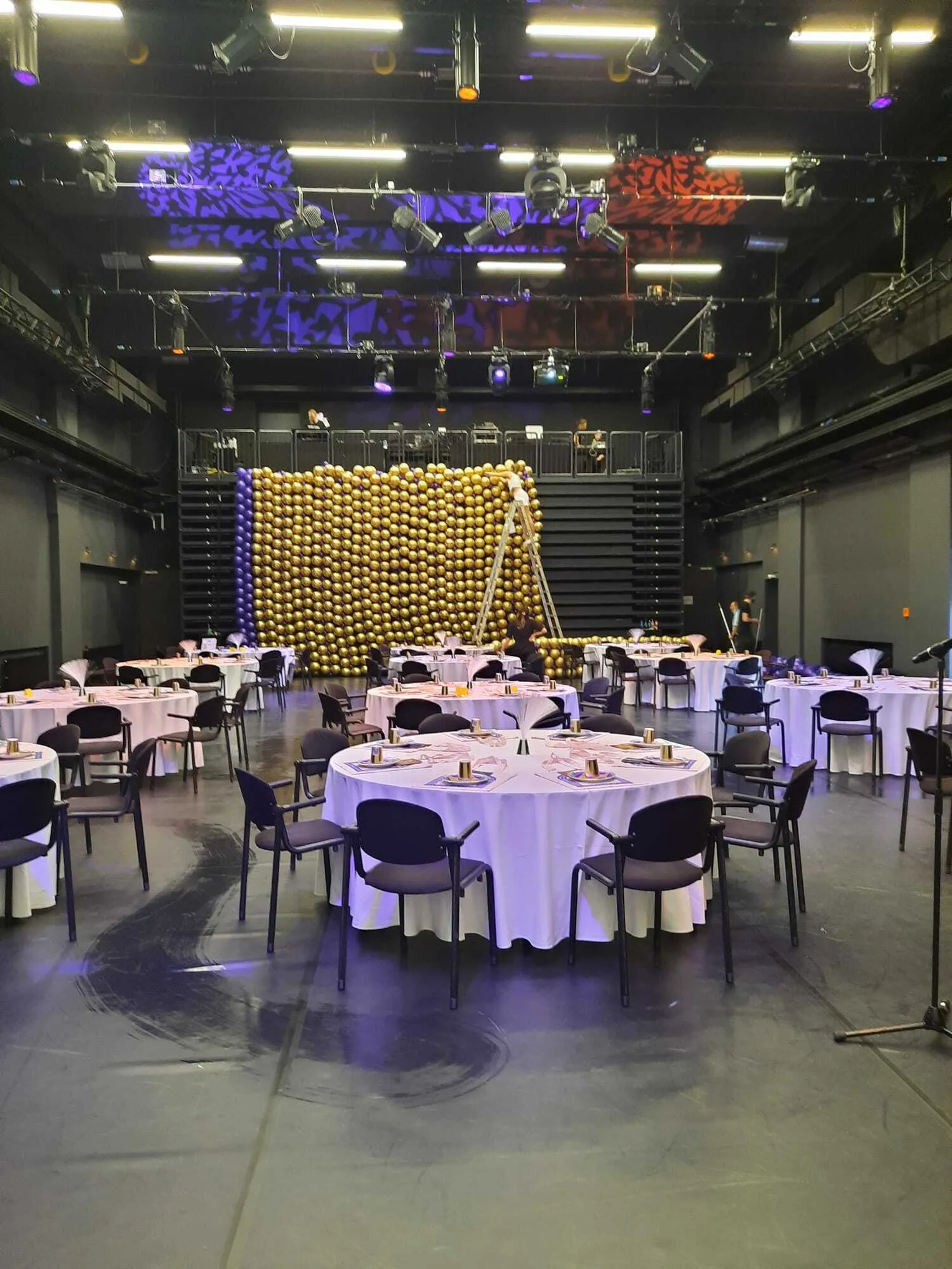 Der Ballonvorhang aus blauen Ballons am Rande und goldenen Ballons in der Fläche vor den dekorierten und eingedeckten Tischen. Der Ballonvorhang aus blauen Ballons am Rande und goldenen Ballons in der Fläche vor den dekorierten und eingedeckten Tischen.