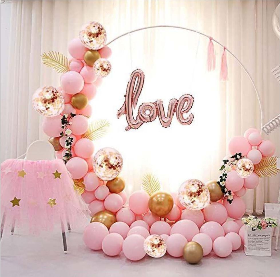 Auf dem Bild wird ein rosafarbenes Luftballon-Arrangement in runder Form dargestellt mit dem Text "Love"